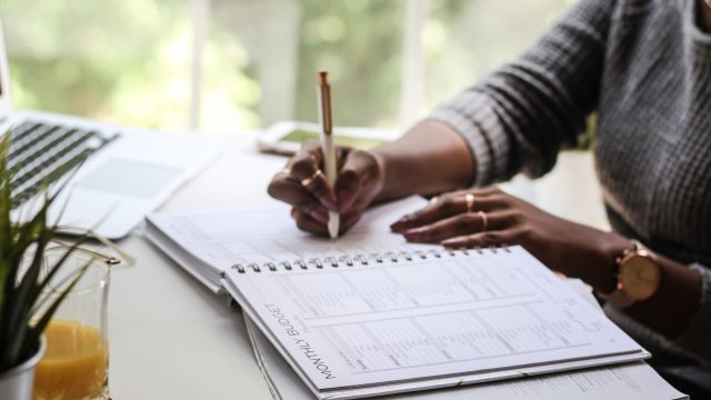 Woman Filling Out Monthly Budget Sheet